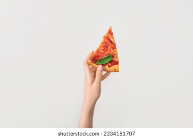 Woman holding slice of tasty pizza on white background - Powered by Shutterstock