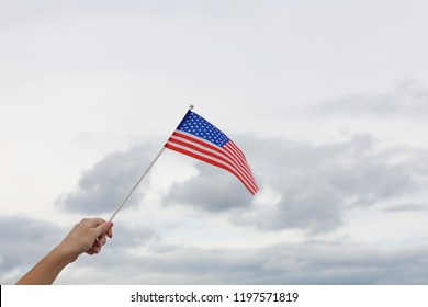 Woman Holding Small American Flag Outdoors, Closeup. Space For Text