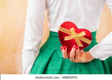 Woman Holding Small Present Box Behind Her Back