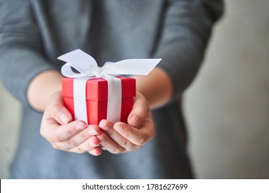 Frauen, die kleine rote Geschenkbox in Händen halten.