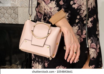 Woman Is Holding A Small Stylish Bag (clutch) Of Soft Beige Color With An Iron Metal Ring