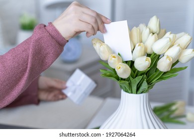 Woman Holding Small White Gift Box And Greeting Card With Bouquet Of White Tulips Flowers On Valentines Day. 