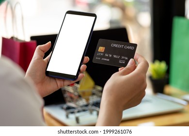 Woman Holding Smart Phone And Credit Card For Shopping Online.Blank Screen Monitor For Graphic Display Montage.