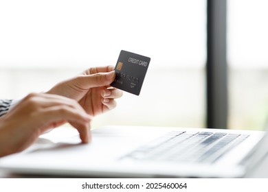 Woman Holding Smart Phone And Credit Card For Shopping Online.Blank Screen Monitor For Graphic Display Montage.Pay For Goods By Credit Card Through A Smartphone .