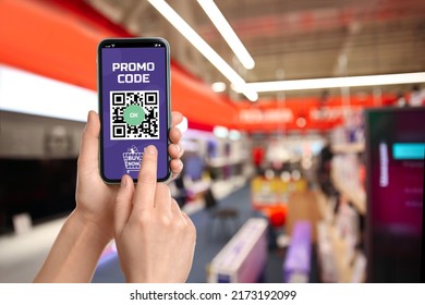 Woman holding smartphone with activated promo code in shopping mall, closeup - Shutterstock ID 2173192099