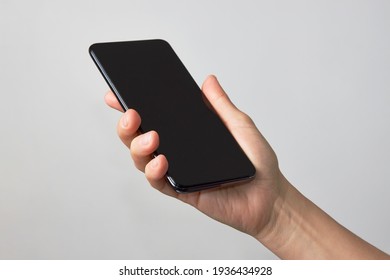 Woman Holding Smartphone With Black Screen. Hand Holding Phone On White Background With Copy Space                   