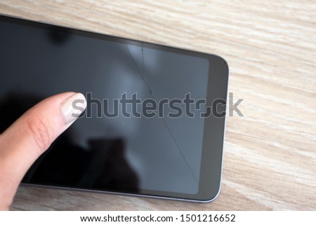 Woman holding smartphone with broken display in hand with selective focus. Crashed device, repair service