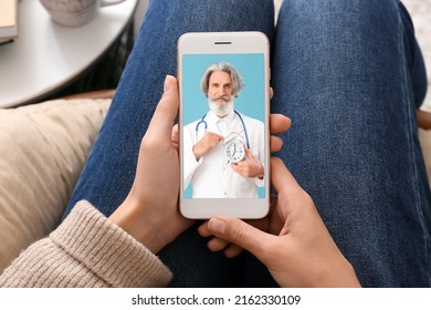 Woman holding smartphone with doctor on screen, closeup. Concept of telemedicine
