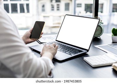 A Woman Holding A Smartphone And Using A Laptop Uses A Smartphone. Chat With Friends Through Instant Messaging To Discuss Business Together And Use Your Laptop To Find Information On The Web.