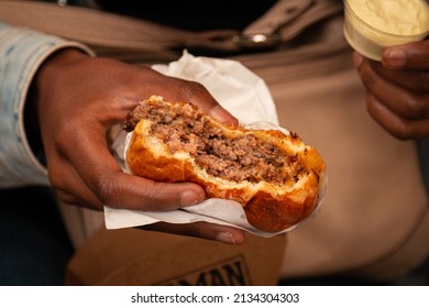Woman holding Smash Burger with American Cheese. Delicious Smash Burger. Black woman eating a tasty smash burger.