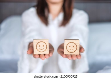 Woman Holding Smile And Angry Emotion Face Block. Customer Choose Emoticon For User Reviews. Service Rating, Mental Health, Positive Thinking, Satisfaction, Evaluation And Feedback Concept