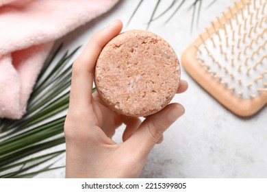 Woman Holding Solid Shampoo Bar At Light Grey Table, Closeup. Hair Care