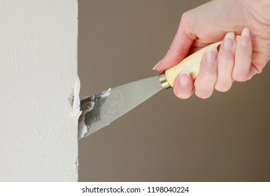 Woman Holding A Spatula, Fixing Broken Wall With Plaster. 