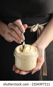 Woman Holding Spoon And Jar Of Delicious Mayonnaise, Closeup