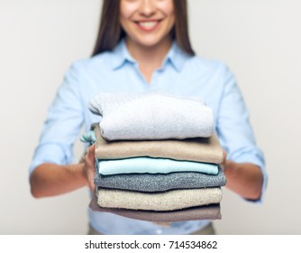 Woman Holding Stack Of Folded Clothes. Isolated Laundry Concept.
