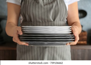 Woman Holding Stack Of Plates, Closeup