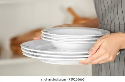 Woman Holding Stack Of Plates, Closeup