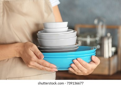 Woman Holding Stack Of Plates, Closeup