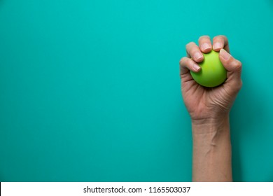 Woman Holding Stress Ball On Green Background