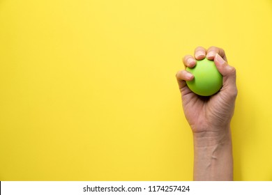 Woman Holding Stress Ball On Yellow Background