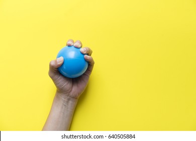 Woman Holding Stress Ball On Yellow Background