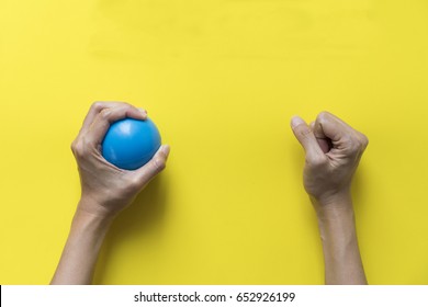 Woman Holding Stress Ball On Yellow Background