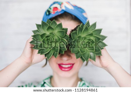 Woman holding succulents near the face, concept, lifestyle