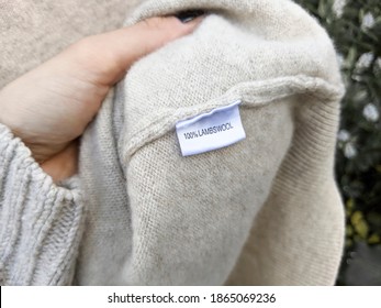 Woman is holding a sweater made out of Beige Lamb Wool.
100% Lamb Wool Label