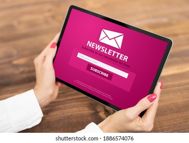 Woman Holding Tablet With Newsletter Signup Page On Screen