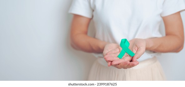 woman holding Teal Ribbon for January Cervical Cancer Awareness month. Uterus and Ovaries, Cervix, Endometriosis, Hysterectomy, Uterine fibroids, Reproductive, Healthcare and World cancer day - Powered by Shutterstock