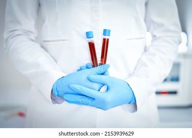 Woman holding test tube with blood and mixing machine