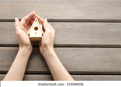 Woman Holding Tiny Wooden House