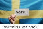 Woman holding title sign with text Vote on swedish flag background. Elections in Sweden, national pride, Sverige political involvement. High quality 