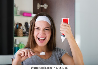 Woman Holding A Toothbrush And A Toothpaste