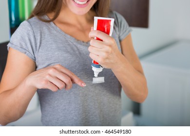 Woman Holding A Toothbrush And A Toothpaste Tube