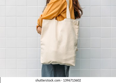 Woman is holding tote bag canvas fabric for mockup blank template. - Shutterstock ID 1396713602