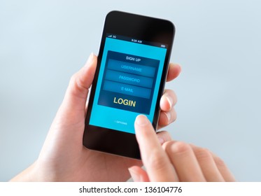 Woman holding and touching on modern mobile smartphone with login form on a screen. - Powered by Shutterstock