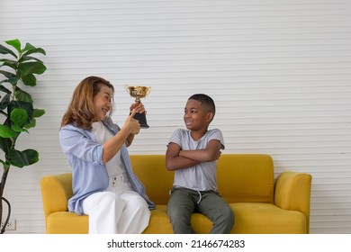 Woman Holding Trophy And Making Thumbs Up Sign Congratulations Kid Boy, Grandmother Thumb Up Give To Congratulate Little Boy