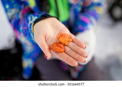 Woman Holding Two Pieces Of Dried Apricots