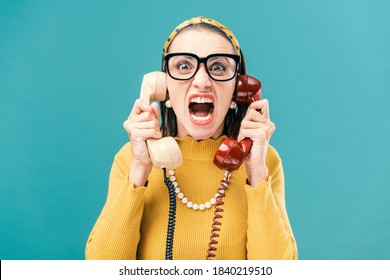 Woman Holding Two Telephone Receivers And Shouting, She Is Stressed And Angry