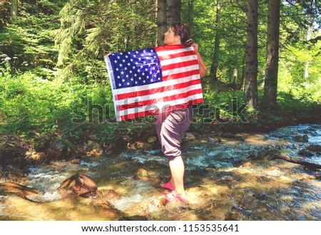 Woman holding a USA flag in the nature