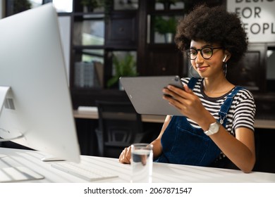 Woman Holding And Using Hand Gestures Swipe Up Digital Tablet Computer Sitting At The Desk. Browsing The Internet. Background Office.