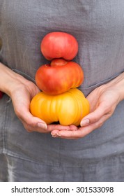 Woman Holding Variety Of Organic Heirloom Tomatoes