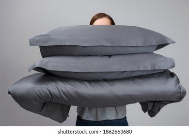 The Woman Is Holding A Warm Duvet And Gray Feather Pillows. Bedding For Sleeping.