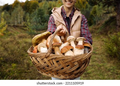 Woman holding wicker basket with fresh wild mushrooms outdoors - Powered by Shutterstock