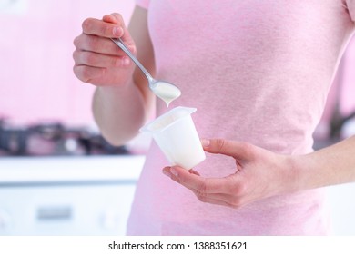 Woman Holding Yogurt Cup And Yogurt Spoon Close Up At Kitchen At Home 