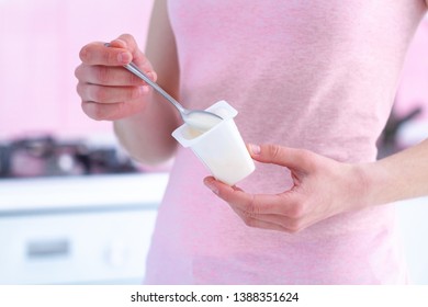 Woman Holding Yogurt Cup And Yogurt Spoon Close Up At Kitchen At Home 