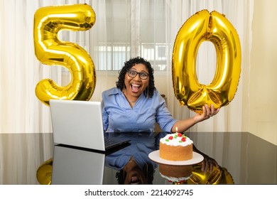  Woman Holds 50th Birthday Balloon, Sitting At Her Desk