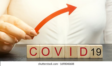 Woman holds up arrow over the word Covid-19. The concept of increased mortality and the diagnosis of new cases of coronavirus infection. Pandemic. Quarantine. Ncov - Shutterstock ID 1690040608