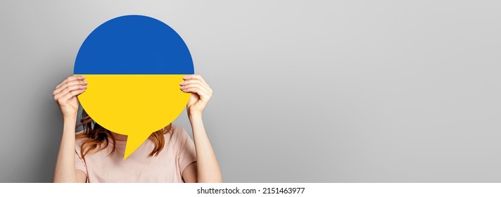 Woman Holds Blank Speech Bubble With Ukrainian Flag Isolated Over Grey Studio Background. Copy Space. Web Banner